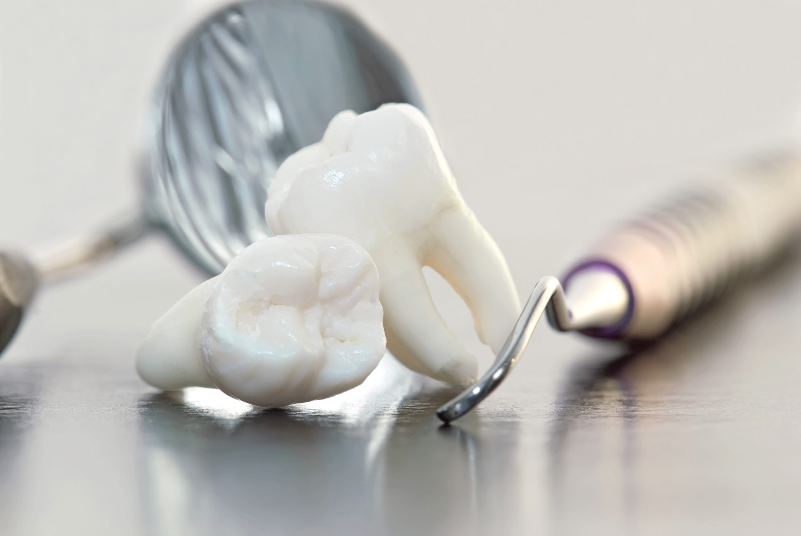 A tooth with a spoon and other tools on the table.