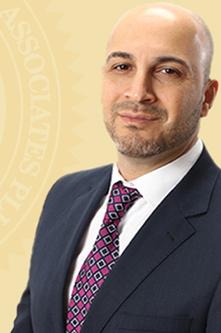 A man in suit and tie standing next to a yellow background.
