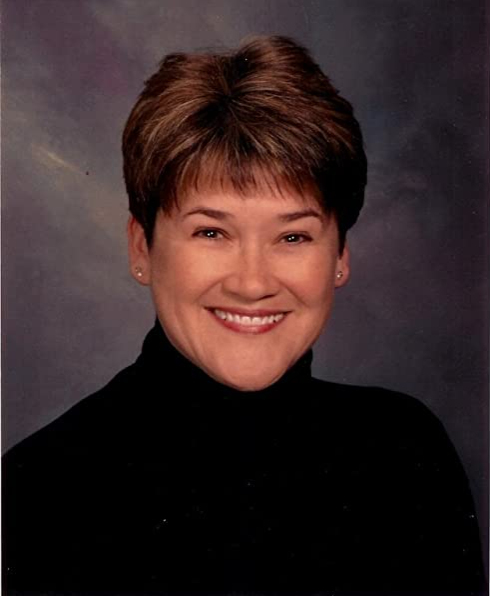 A woman with short hair wearing a black shirt.