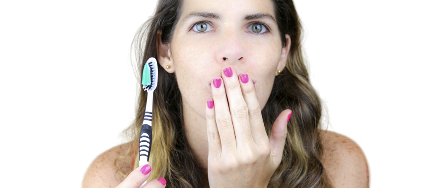 A woman holding a toothbrush in her hand.