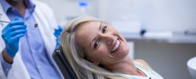 A woman sitting in the dentist chair smiling for the camera.