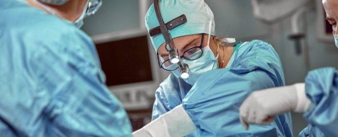 A surgeon is performing surgery on someone in the operating room.