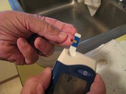 A person is taking a blood sample from the monitor.