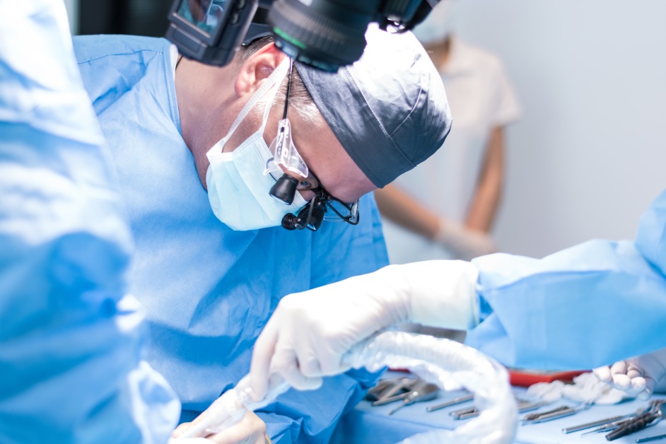 A surgeon is performing surgery on someone in the hospital.