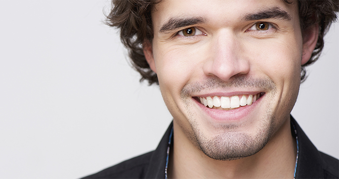 A man with white teeth smiling for the camera.